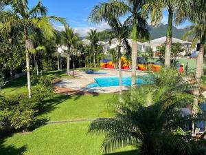 - une vue sur la piscine bordée de palmiers dans l'établissement Maresias, à São Sebastião