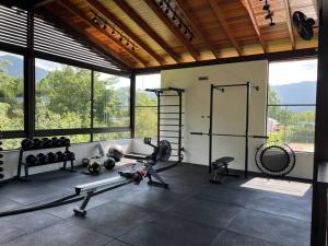 - une salle de sport avec des poids et des équipements dans une pièce dotée de fenêtres dans l'établissement Maresias, à São Sebastião