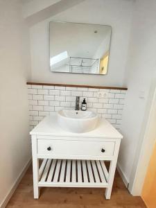 a bathroom with a white sink and a mirror at Ferienwohnung im Grünen in Neustadt bei Coburg