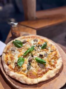 uma pizza sentada em cima de uma mesa de madeira em PineApple Surf em Ahangama