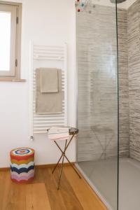prysznic ze szklanymi drzwiami i stołek w łazience w obiekcie Villa l'Essiccatoio Deluxe Morcella w mieście Morcella
