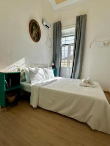 a bedroom with a white bed and a window at Ti Maria Guest House in Faro
