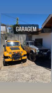 twee vrachtwagens geparkeerd voor een garage bij Cantinho do sossego in Campos do Jordão
