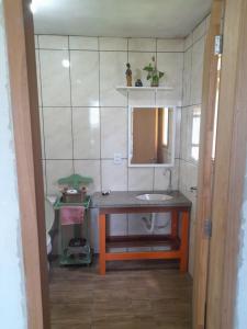 a small bathroom with a sink and a mirror at Refúgio da Mata Atlântica Sobrado Centenário in Torres