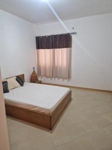 um quarto com uma cama e uma janela em Condomínio palma azul II em Praia