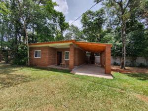 a small brick house with a porch in a yard at Cabañas Selva Verde in Puerto Iguazú