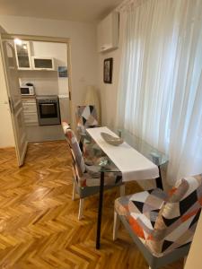 a dining room with a table and chairs and a kitchen at Garden apartmani 3 in Vračar (historical)