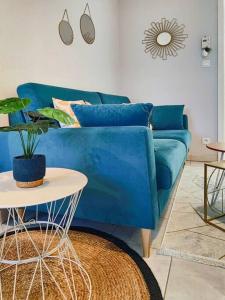 - un canapé bleu dans le salon avec une table dans l'établissement Le Thiers Bleu proche Gare - Centre avec Parking et Netflix, à Mulhouse