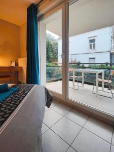 - une chambre avec un lit et une grande fenêtre en verre dans l'établissement Le Thiers Bleu proche Gare - Centre avec Parking et Netflix, à Mulhouse