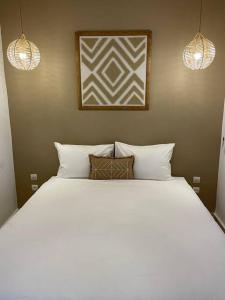 um quarto com uma grande cama branca e 2 almofadas em Riad ROSE private Riad with jacuzzi em Marrakech