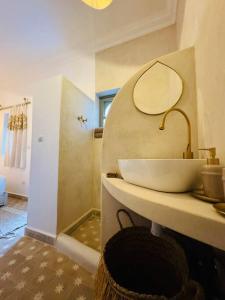 uma casa de banho com um lavatório e um espelho numa prateleira em Riad ROSE private Riad with jacuzzi em Marrakech