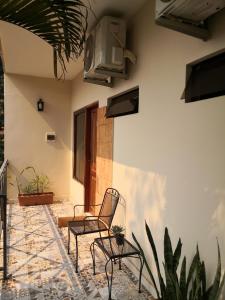 un patio con 2 sillas y TV en la pared en De la Mora Hostal, en Fernando de la Mora