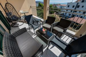 um pátio exterior com cadeiras e uma mesa com uma mesa em Sun Island Apartment em Trogir