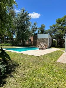 a swimming pool with a bench next to a house at Casa quinta WhiteHouse in San José del Rincón