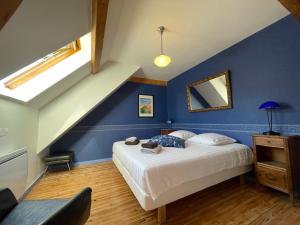 a bedroom with a bed and a blue wall at l'Ancienne Ecole du Villard in Saint-Pierre-dʼEntremont