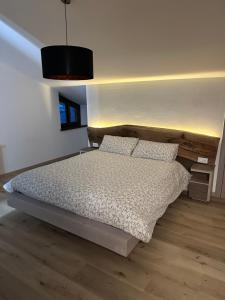 a bedroom with a bed and a pendant light at Affittacamere Il Pettirosso in Moggio Udinese