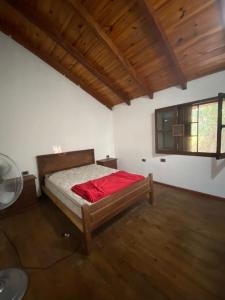 1 dormitorio con 1 cama en una habitación con suelo de madera en Casa quinta WhiteHouse en San José del Rincón