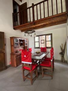 a dining room with a table and red chairs at Casa quinta WhiteHouse in San José del Rincón