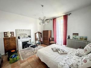 sypialnia z łóżkiem, stołem i kominkiem w obiekcie Très belle maison avec jardin à 10min des remparts w Awinionie