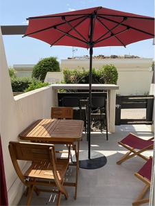 a table and chairs and an umbrella on a patio at Cap d'Agde Naturiste Port Nature 2 in Cap d'Agde