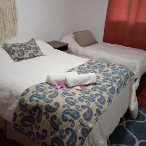 two beds in a room with towels on the bed at La Baquiana in Mercedes