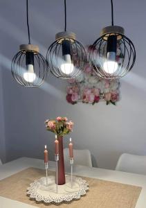 uma mesa com duas velas e um vaso com flores em Sun Island Apartment em Trogir