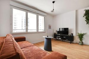 een woonkamer met een bank en een televisie bij Charming Apartment in Saint-Ouen - GetHosted in Saint-Ouen