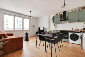 a kitchen and living room with a table and chairs at Charming Apartment in Saint-Ouen - GetHosted in Saint-Ouen