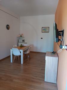 una camera con tavolo, sedie e televisore di Casa vacanze Sicilia a Casteltermini