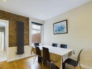 a dining room with a table and chairs at Cosy 4 bedroom, 3 bathroom home - 5 mins from East Croydon station in South Norwood