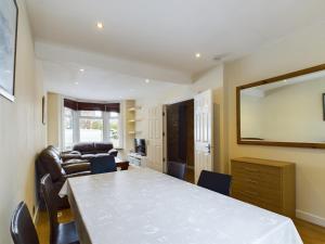 ein Wohnzimmer mit einem Tisch und einem Sofa in der Unterkunft Cosy 4 bedroom, 3 bathroom home - 5 mins from East Croydon station in South Norwood