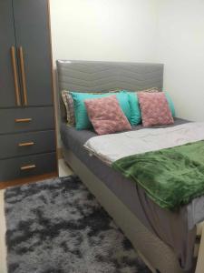 馬尼拉的住宿－FAZZI CONDOTEL Shore 3 Residences，一间卧室配有带枕头的床铺和梳妆台