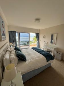 1 dormitorio con 1 cama grande y ventana grande en Holiday Villa with stunning views near beach., en Plettenberg Bay