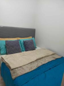 a bed with blue sheets and blue pillows on it at FAZZI CONDOTEL Shore 3 Residences in Manila