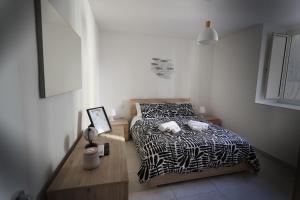 a bedroom with a bed with a black and white comforter at Casa Cicerone Lucrino in Pozzuoli