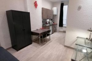 een woonkamer met een tafel en een keuken bij Studio Capucins 2 pers Place des Terreaux in Lyon