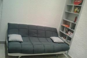 eine Couch in einem Wohnzimmer mit Bücherregal in der Unterkunft Studio Capucins 2 pers Place des Terreaux in Lyon