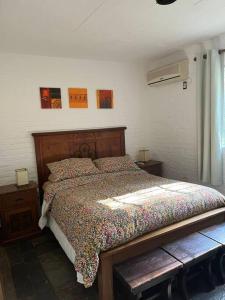 ein Schlafzimmer mit einem Bett mit einem Kopfteil aus Holz in der Unterkunft Casa en bella vista, Clarita in Bella Vista