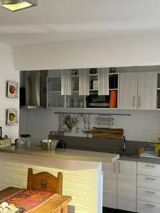 a kitchen with white cabinets and a table and a counter at Casa en bella vista, Clarita in Bella Vista