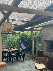 eine Terrasse mit einem Tisch, Stühlen und einem Kamin in der Unterkunft Casa en bella vista, Clarita in Bella Vista