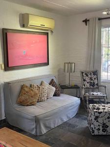 ein Wohnzimmer mit einem Sofa und einem TV in der Unterkunft Casa en bella vista, Clarita in Bella Vista