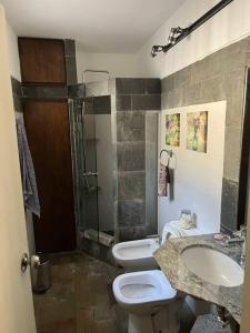 ein Badezimmer mit 2 WCs, einem Waschbecken und einer Dusche in der Unterkunft Casa en bella vista, Clarita in Bella Vista