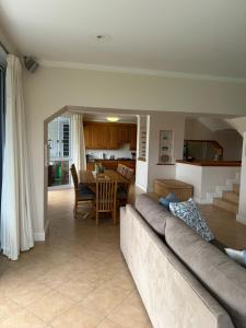 普利登堡湾Holiday Villa with stunning views near beach.的客厅里有一张沙发和一张桌子。