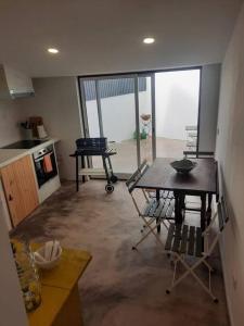 a living room with a table and a kitchen at Casa da Xica in Torrão