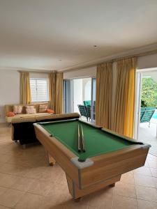 a living room with a pool table and a couch at Holiday Villa with stunning views near beach. in Plettenberg Bay