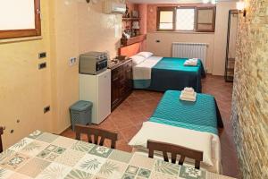 Habitación con 2 camas y cocina con mesas. en Alloggio Gladiolo, en Monticchio