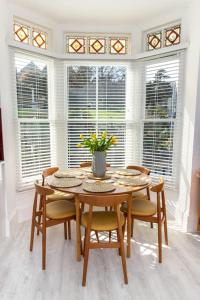 a dining room with a table and chairs and windows at Flat 1, Church House in Ilfracombe