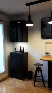 une cuisine avec des placards noirs, une table et un tabouret dans l'établissement Superbe studio avec terrasse, à Courbevoie