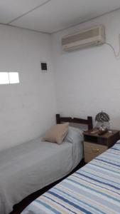 um quarto com uma cama e uma mesa de cabeceira com uma ventoinha em La Baquiana 2 em Mercedes