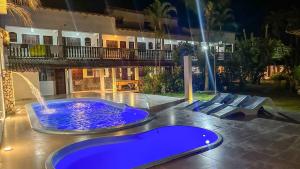a pool with a fountain in the middle of a house at Alfa Mar Pousada in Abraão